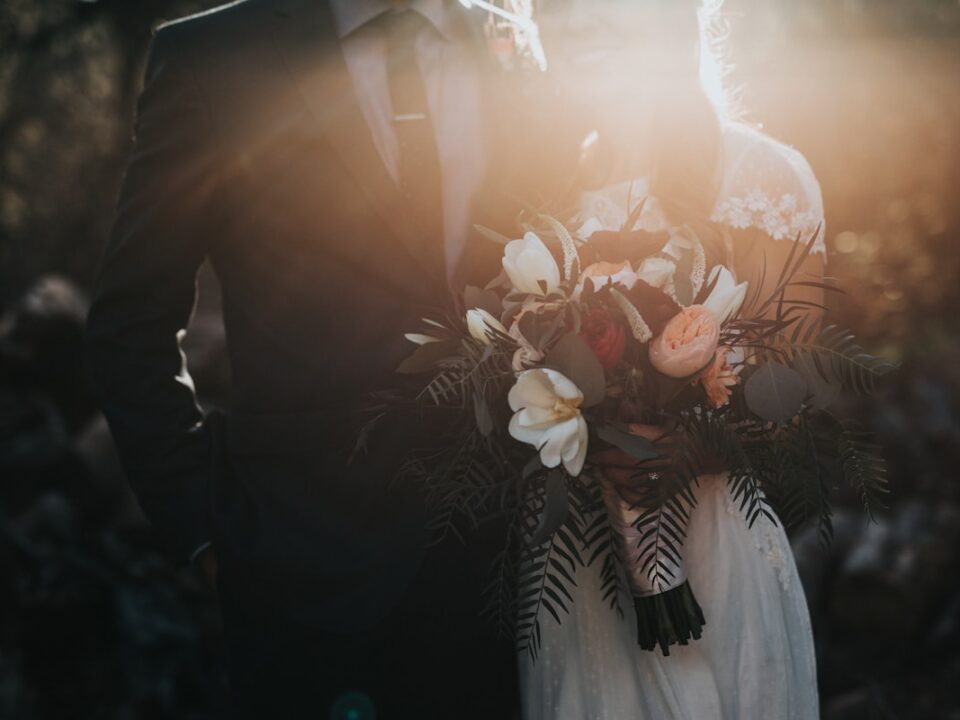 Couple de mariés s'amusant dans un photobooth lors de leur mariage - Guide pour bien choisir son photobooth